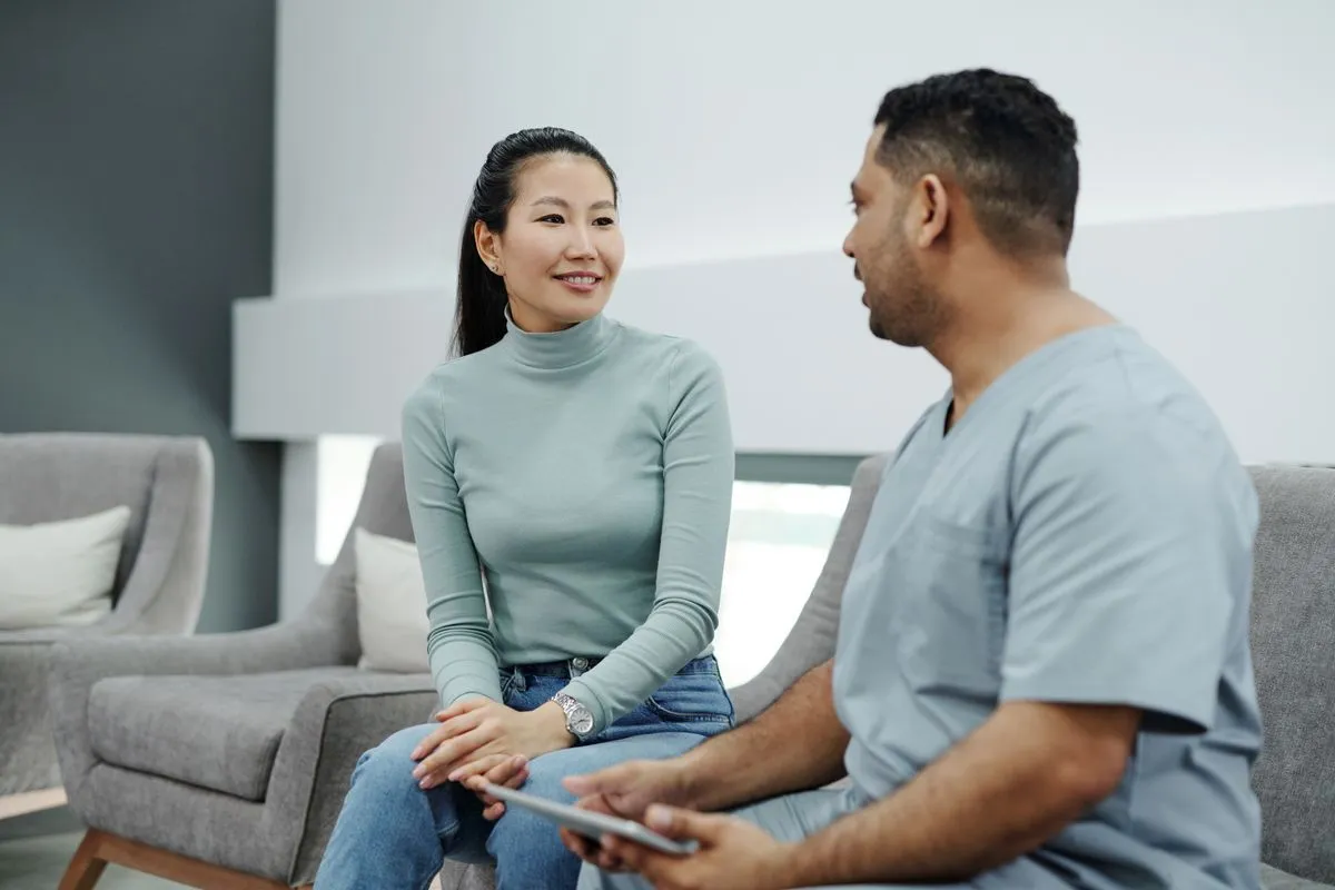 Two people talking during a medical consultation, with a tablet in hand.